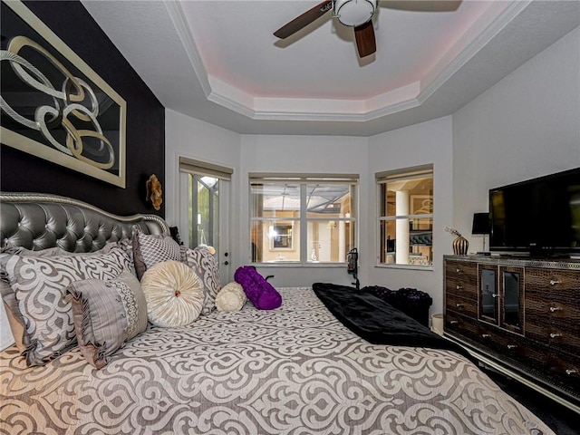 bedroom with access to exterior, ceiling fan, and a tray ceiling