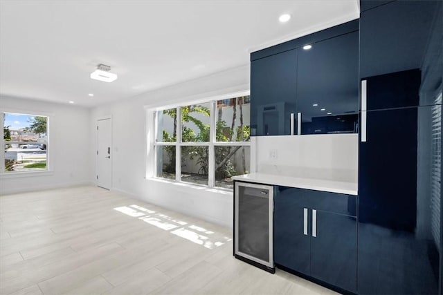 924 Coquina Ln Unit 3, Vero Beach, FL 32963 - kitchen with blue cabinetry, wine cooler, light countertops, modern cabinets, and light wood-type flooring