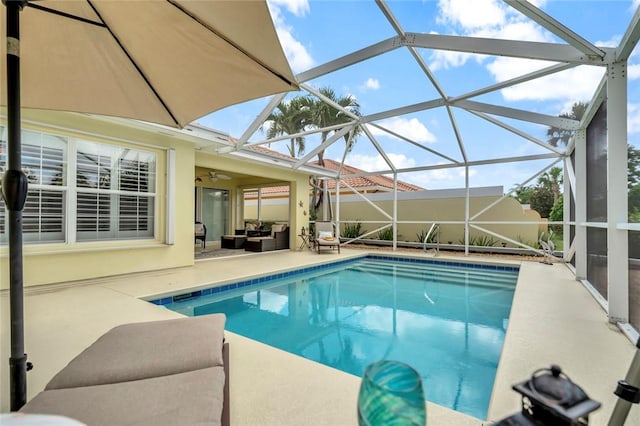 outdoor pool featuring a patio, glass enclosure, and ceiling fan