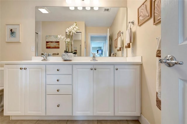 bathroom with double vanity and tile patterned flooring