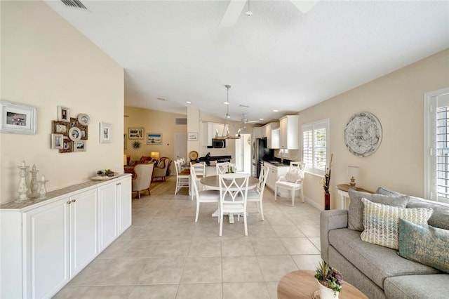 living room with light tile patterned floors, ceiling fan, and baseboards