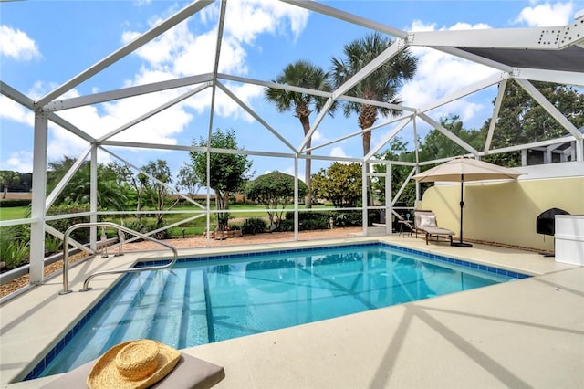 outdoor pool featuring a patio and glass enclosure
