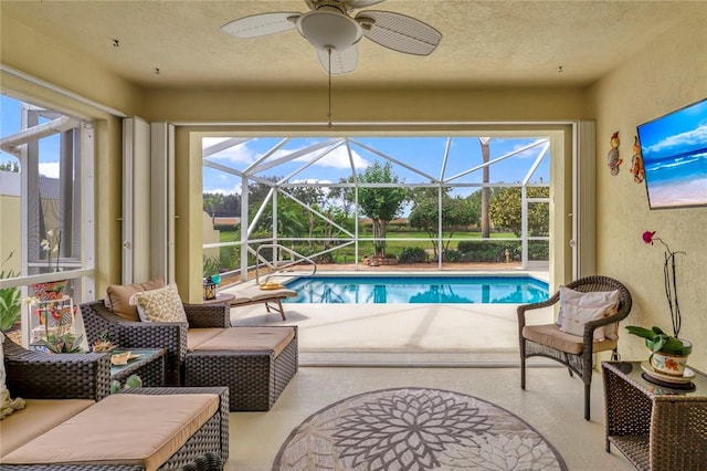 swimming pool featuring a patio area, a ceiling fan, and a lanai