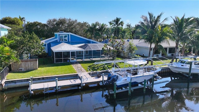 back of property featuring a water view, a yard, and glass enclosure