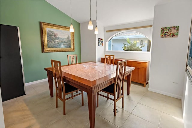 dining space with light tile patterned floors and vaulted ceiling