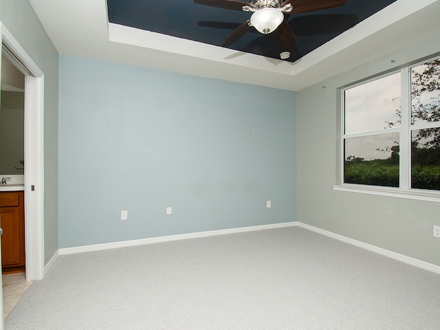351 Monaco Pl, Vero Beach, FL 32960 - empty room featuring a raised ceiling, light colored carpet, and a ceiling fan