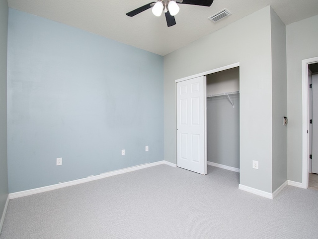 unfurnished bedroom featuring a closet, baseboards, visible vents, and light colored carpet