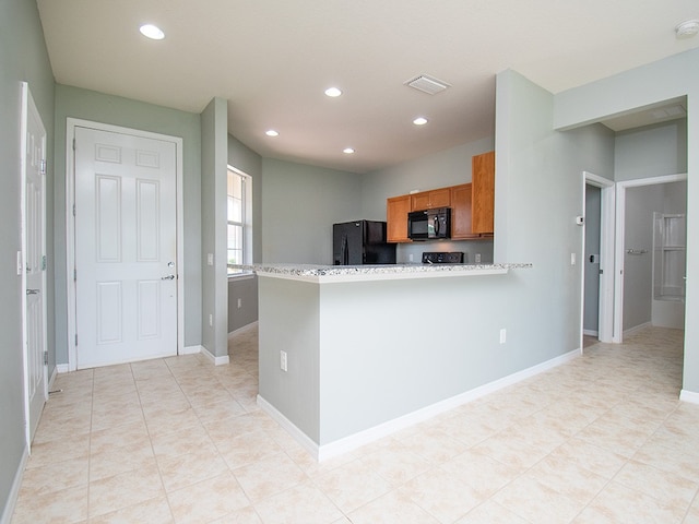 351 Monaco Pl, Vero Beach, FL 32960 - kitchen with black appliances, brown cabinets, recessed lighting, light countertops, and light tile patterned floors