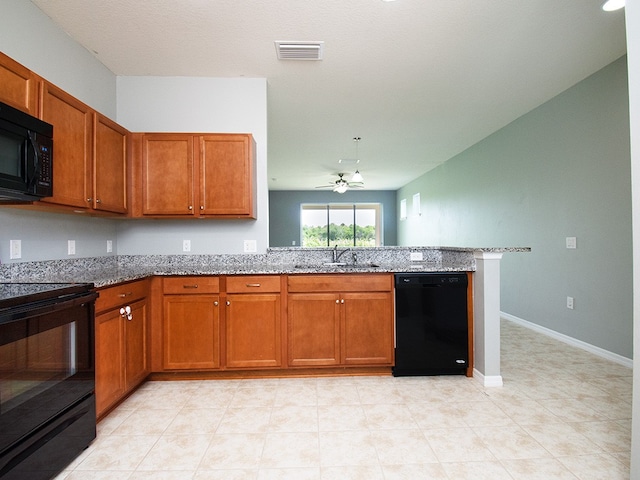 kitchen featuring kitchen peninsula, black appliances, sink, ceiling fan, and light stone countertops