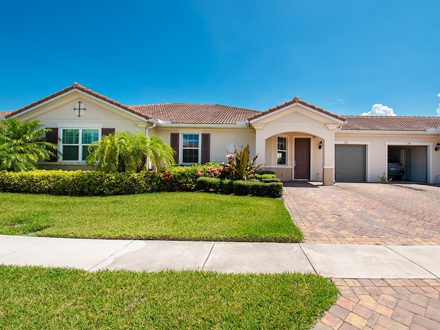 351 Monaco Pl, Vero Beach, FL 32960 - view of front of property with an attached garage, decorative driveway, stucco siding, and a front lawn