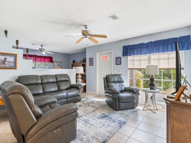 tiled living room featuring a textured ceiling and ceiling fan