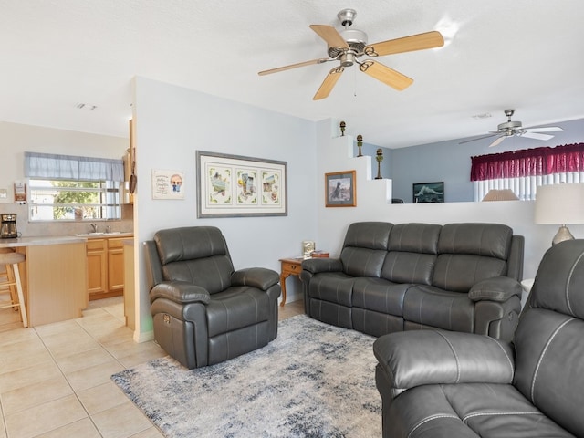 tiled living room featuring ceiling fan and sink