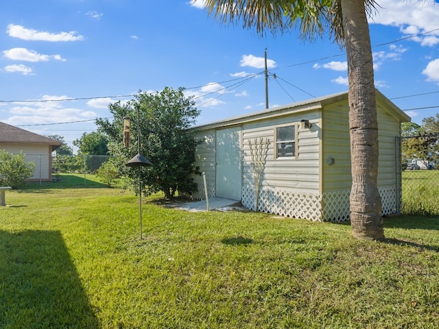 back of property with an outbuilding and a yard