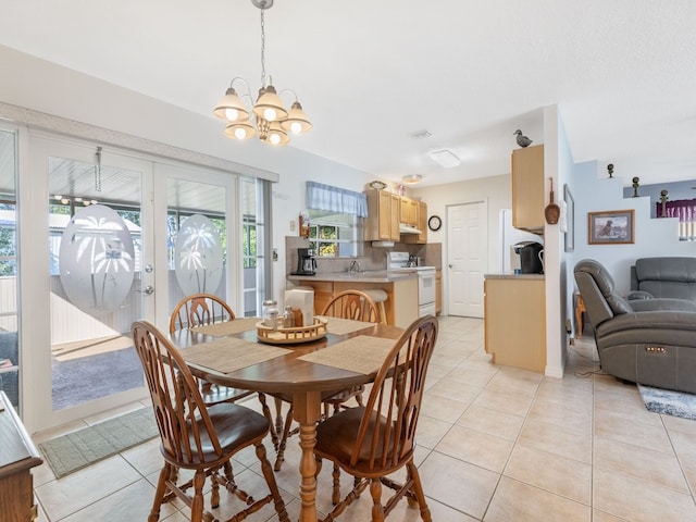 tiled dining area featuring french doors, a notable chandelier, and sink