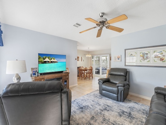 living room featuring a textured ceiling, light tile patterned floors, ceiling fan, and french doors