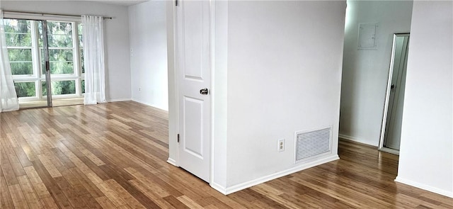 spare room with visible vents, baseboards, and wood finished floors