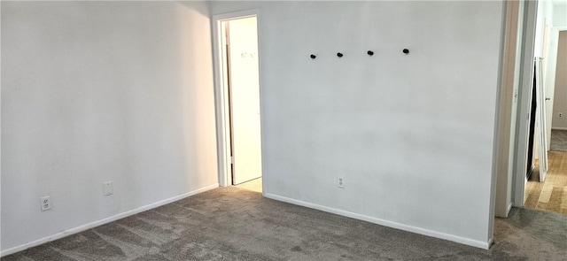 carpeted spare room featuring baseboards