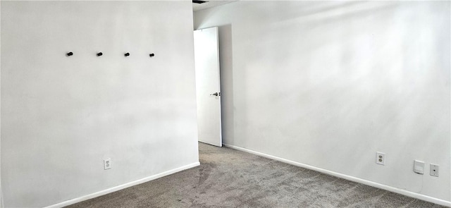 spare room with light colored carpet and baseboards