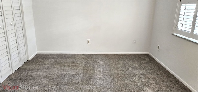 spare room featuring carpet floors and baseboards