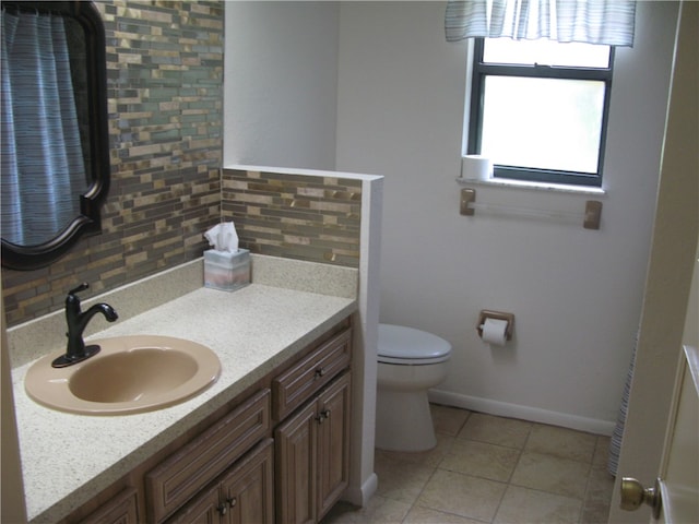 bathroom with toilet, tile patterned flooring, vanity, and tasteful backsplash