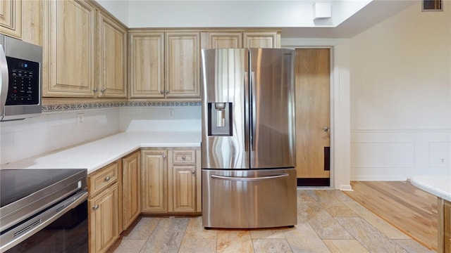 kitchen with light hardwood / wood-style flooring, light brown cabinetry, and stainless steel appliances