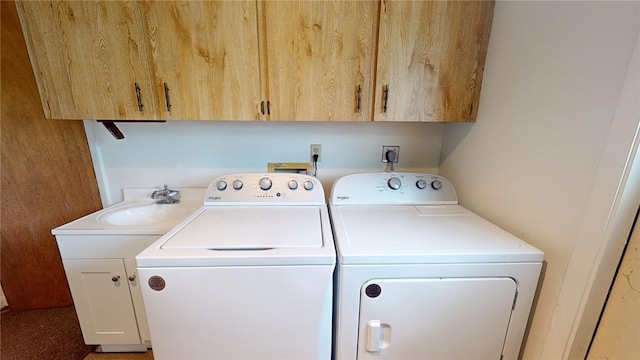 clothes washing area with cabinets and washing machine and clothes dryer