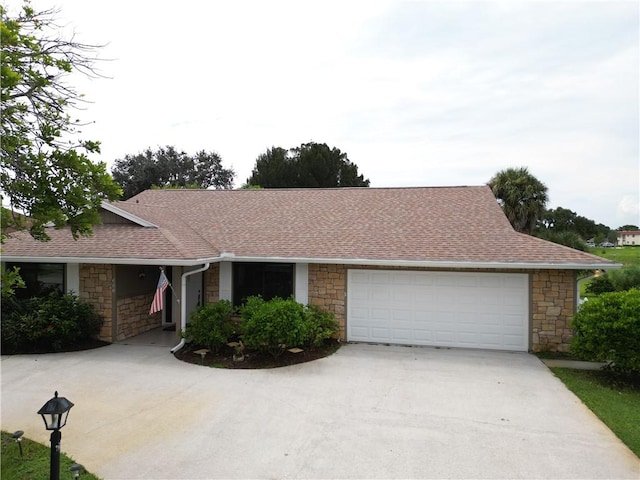 585 W Forest Trl, Vero Beach, FL 32962 - ranch-style home with stone siding, driveway, a shingled roof, and a garage