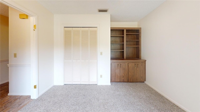 unfurnished bedroom with a closet and carpet flooring