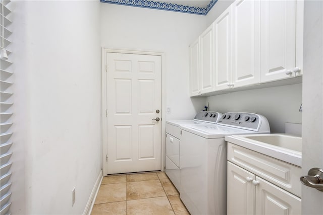 laundry area with washer and dryer, cabinets, and light tile patterned flooring