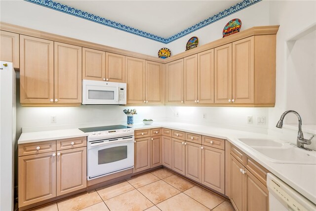 kitchen featuring light tile patterned floors, white appliances, sink, and light brown cabinetry