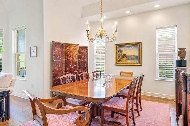 dining room with hardwood / wood-style flooring, a wealth of natural light, and an inviting chandelier