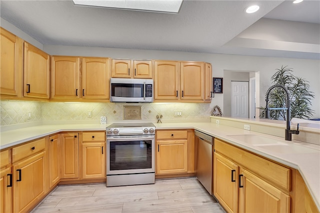 kitchen with decorative backsplash, light hardwood / wood-style flooring, sink, light brown cabinets, and appliances with stainless steel finishes