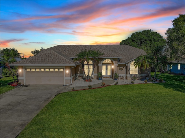 view of front of house with a garage and a yard