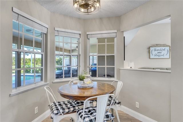 dining area featuring lofted ceiling, a textured ceiling, and light hardwood / wood-style flooring