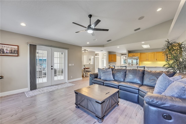 living room featuring french doors, light hardwood / wood-style floors, ceiling fan, and vaulted ceiling