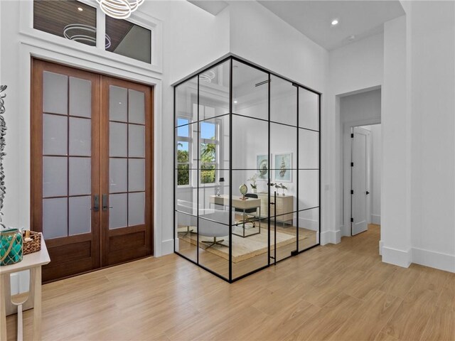 doorway to outside featuring recessed lighting, french doors, baseboards, a high ceiling, and light wood-style floors