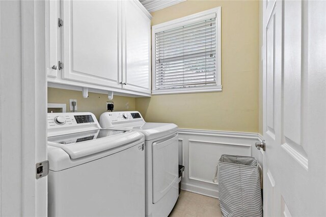 728 S Ocracoke Sq SW, Vero Beach, FL 32968 - laundry area with cabinet space, washing machine and clothes dryer, a wainscoted wall, a decorative wall, and light tile patterned floors
