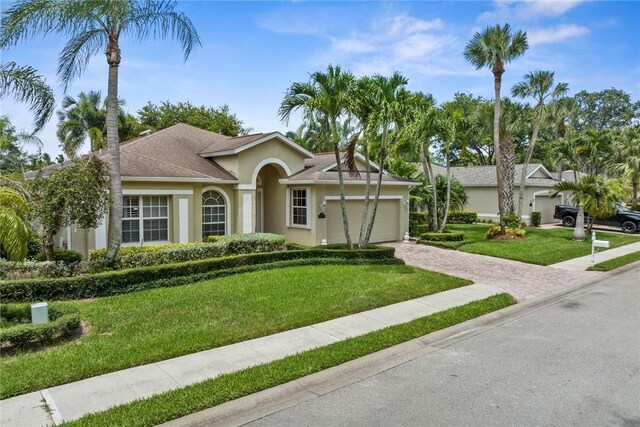 728 S Ocracoke Sq SW, Vero Beach, FL 32968 - ranch-style house featuring stucco siding, a garage, a front lawn, and driveway