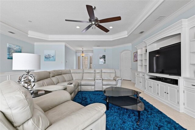 728 S Ocracoke Sq SW, Vero Beach, FL 32968 - living room featuring a raised ceiling, ceiling fan, crown molding, a decorative wall, and a wainscoted wall
