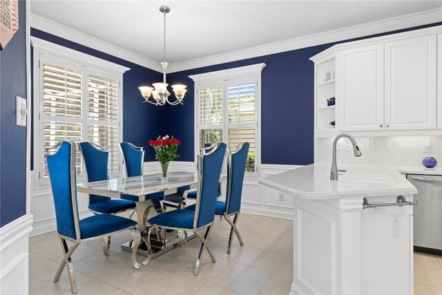 728 S Ocracoke Sq SW, Vero Beach, FL 32968 - dining space featuring a chandelier, wainscoting, a decorative wall, crown molding, and light tile patterned floors