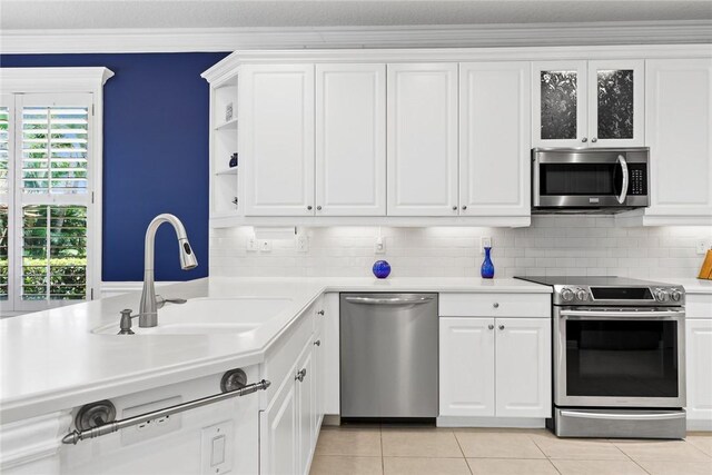 728 S Ocracoke Sq SW, Vero Beach, FL 32968 - kitchen featuring appliances with stainless steel finishes, light countertops, a sink, white cabinetry, and ornamental molding