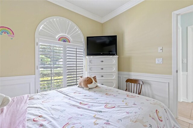 728 S Ocracoke Sq SW, Vero Beach, FL 32968 - bedroom with tile patterned floors, wainscoting, crown molding, and a decorative wall