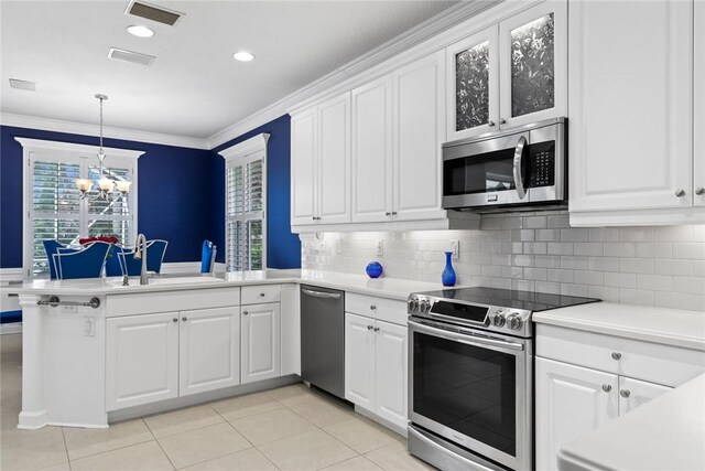 728 S Ocracoke Sq SW, Vero Beach, FL 32968 - kitchen featuring appliances with stainless steel finishes, a sink, a peninsula, light countertops, and ornamental molding