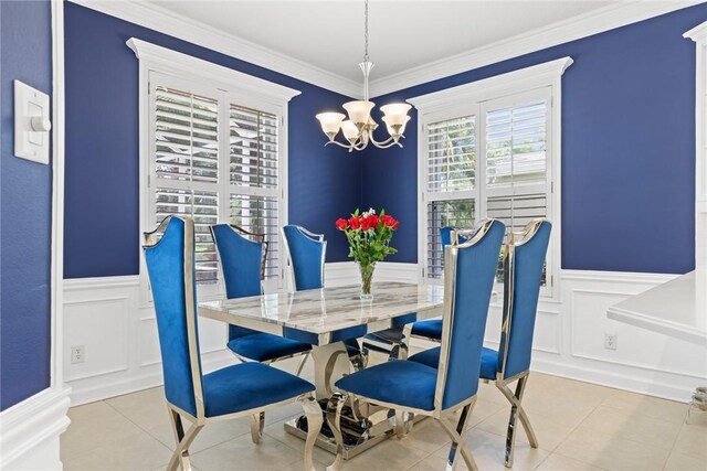 728 S Ocracoke Sq SW, Vero Beach, FL 32968 - dining area with a chandelier, a decorative wall, wainscoting, ornamental molding, and tile patterned floors