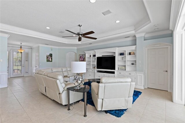 728 S Ocracoke Sq SW, Vero Beach, FL 32968 - living area with light tile patterned floors, ceiling fan, ornamental molding, a tray ceiling, and wainscoting
