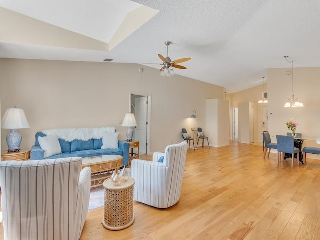 living room with light wood-style floors, visible vents, high vaulted ceiling, and ceiling fan with notable chandelier