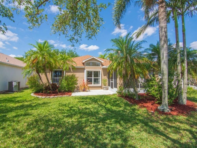 back of property featuring stucco siding, a sunroom, central air condition unit, and a lawn