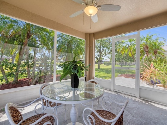 sunroom with outdoor dining area and ceiling fan