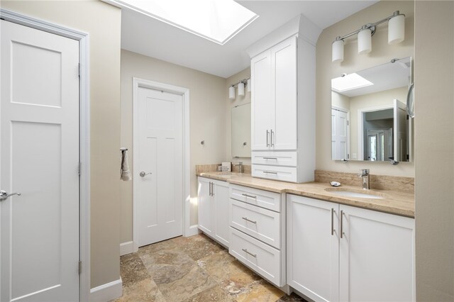 2139 Via Fuentes St Unit 2139, Vero Beach, FL 32963 - bathroom featuring a skylight, double vanity, and stone finish flooring
