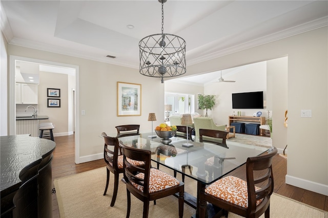 2139 Via Fuentes St Unit 2139, Vero Beach, FL 32963 - dining area with crown molding, wood finished floors, a tray ceiling, a chandelier, and ceiling fan